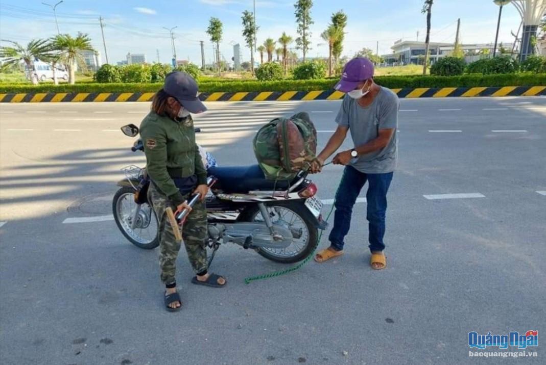 Vợ chồng anh Tuấn, chị Nhi chuyển đồ đạc lên chiếc xe máy do mạnh thường quân Quảng Ngãi trao tặng để về Thanh Hóa. Ảnh: Cộng đồng Thiện nguyện Quảng Ngãi