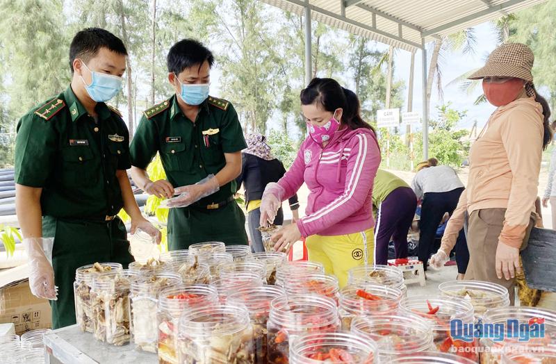 Cán bộ, chiến sĩ Đồn Biên phòng Sa Kỳ và nhân dân thôn Phổ Trường, xã Nghĩa An làm thực phẩm gửi tặng nhân dân TP. Hồ Chí Minh. 