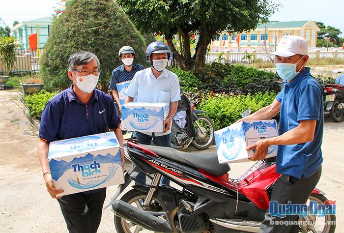 Cán bộ, nhân viên Hội Nông dân TP.Quảng Ngãi dùng xe máy để chở từng thùng hàng đến hỗ trợ người dân khu vực phong tỏa tại thôn Khánh Lâm, xã Tịnh Thiện