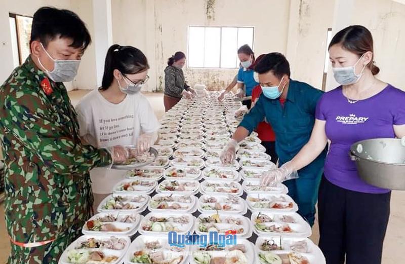 Cán bộ Ban CHQS huyện Bình Sơn cùng các tình nguyện viên chuẩn bị bữa ăn cho các thai phụ.               Ảnh: Lê Đức