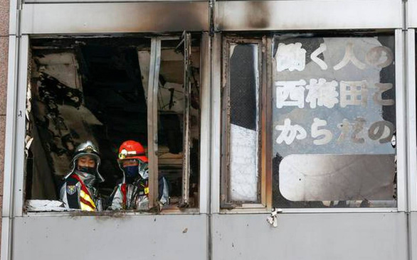 Lính cứu hỏa tại cửa sổ tầng lầu bùng phát đám cháy trong một tòa nhà ở thành phố Osaka, Nhật Bản ngày 17-12 - Ảnh: KYODO NEWS