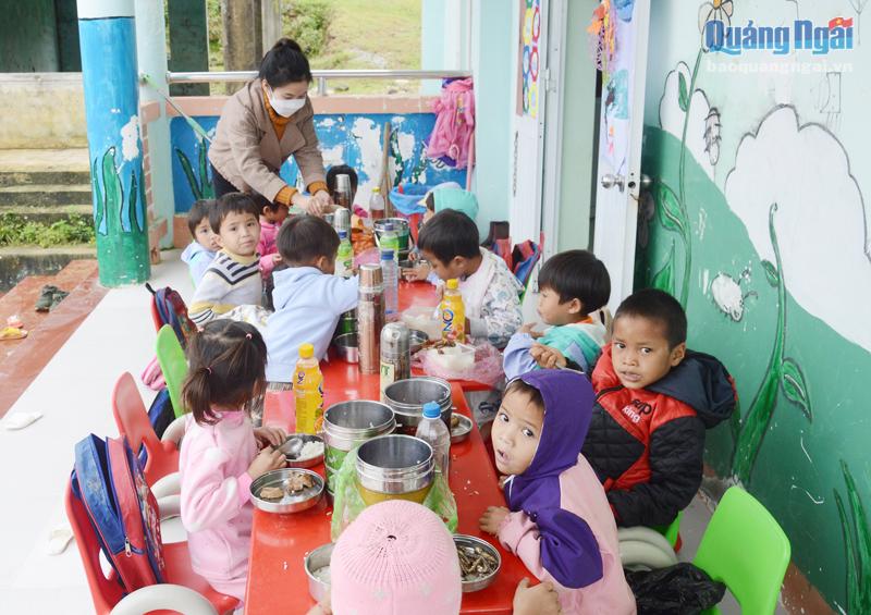 Cô giáo chăm lo bữa ăn cho học sinh ở thôn Quế.                                    Ảnh: N.VIÊN
