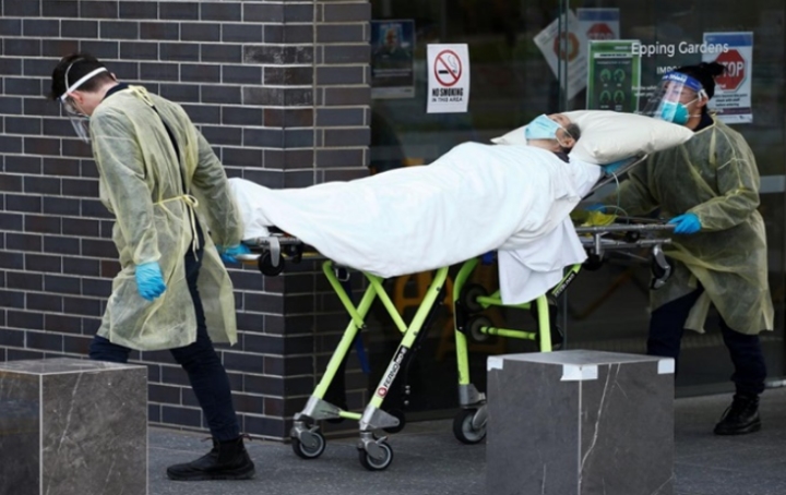 Nhân viên y tế đưa người bệnh rời khỏi nhà dưỡng lão tại Melbourne lên xe cấp cứu. (Ảnh: Reuters)