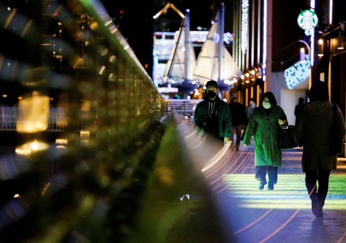 Khách bộ hành đeo khẩu trang ở thủ đô Tokyo ngày 22-1. Ảnh: Reuters