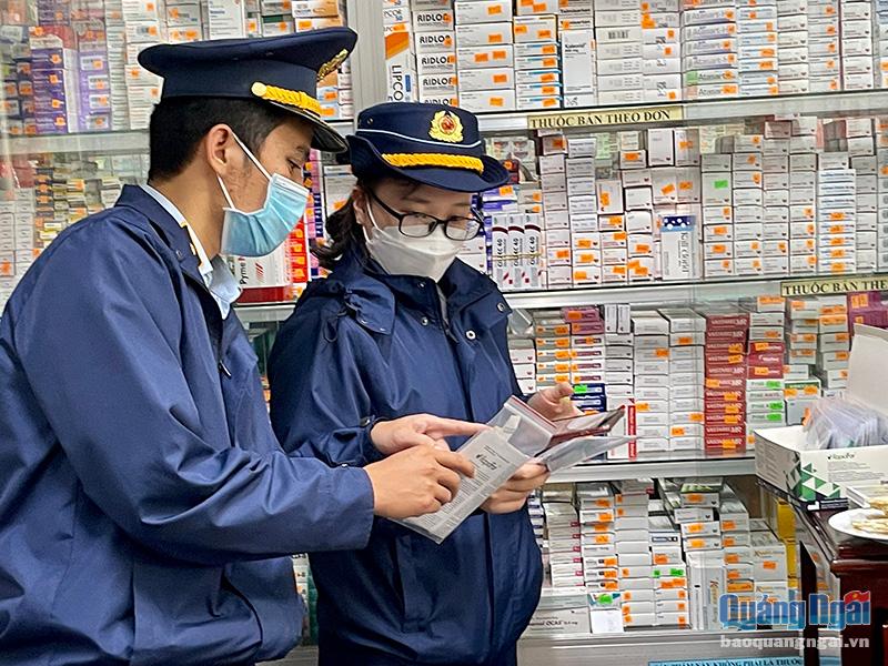 Lực lượng Quản lý thị trường kiểm tra việc kinh doanh Kit test Covid-19 tại một quầy thuốc ở TP.Quảng Ngãi. Ảnh: TL