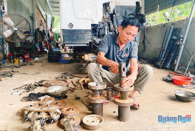 Ông Lê Ngọc Bé, ở thôn Kỳ Thọ Bắc, xã Hành Đức (Nghĩa Hành), đang sửa chữa máy móc nông cụ.