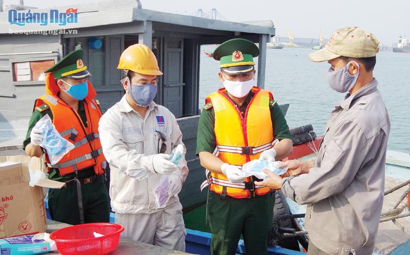 Cán bộ Đồn Biên phòng Cửa khẩu cảng Dung Quất (Bộ đội Biên phòng tỉnh) tặng khẩu trang phòng, chống dịch Covid-19 cho người lao động làm việc tại cảng Dung Quất.       Ảnh: VĂN TÁNH