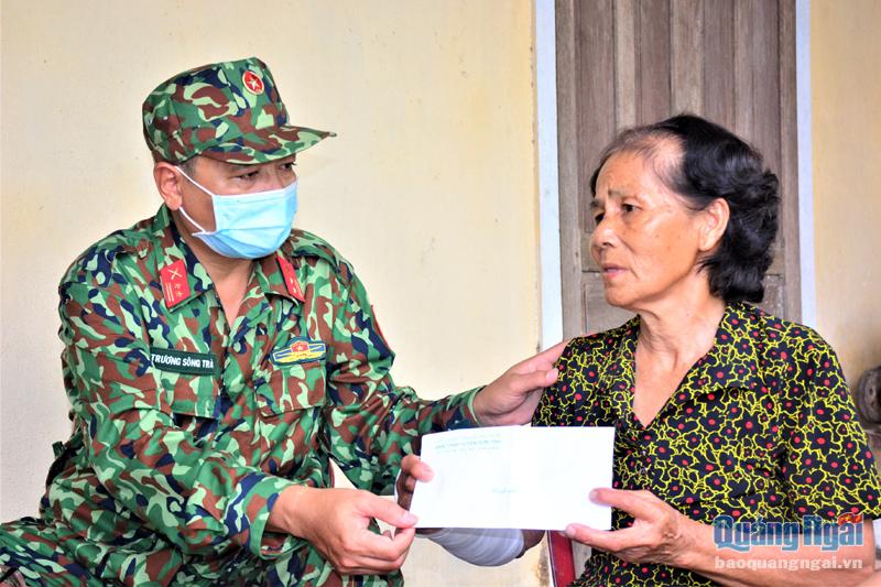 Đại diện Ban CHQS huyện Sơn Tịnh tặng quà cho bà Nguyễn Thị Thạch, là thương binh, ở thôn Đức Sơn, xã Tịnh Hiệp. 