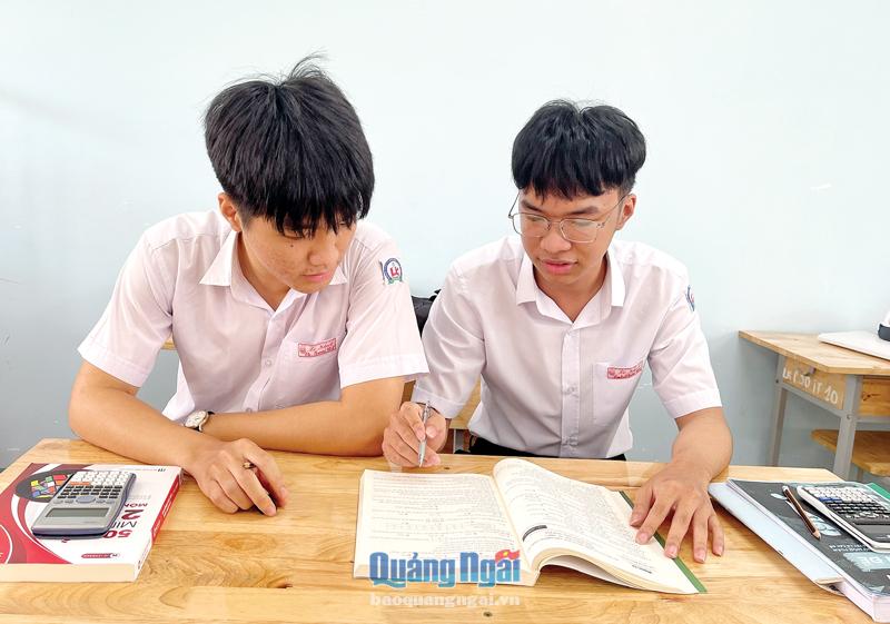 Em Tống Anh Khôi (bên phải) thường xuyên trao đổi bài với các bạn để nắm vững kiến thức đã học.