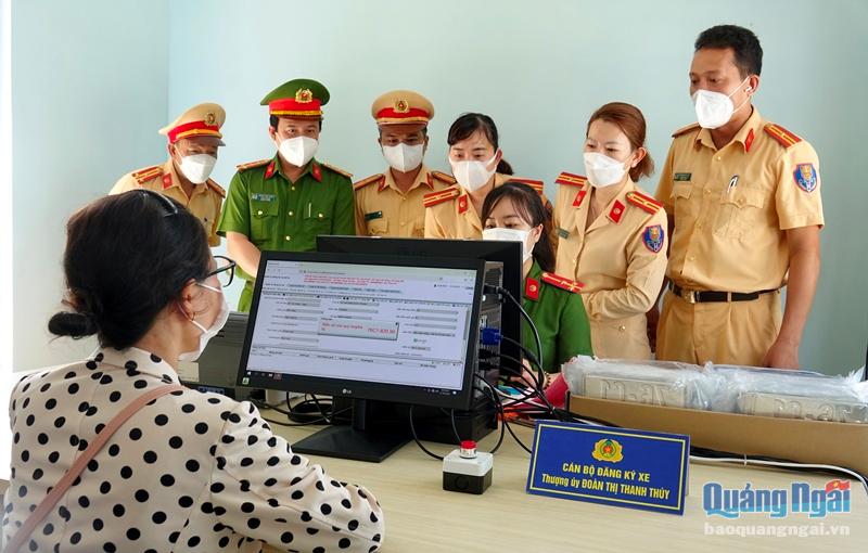 Đại tá Hoàng Anh Tuấn, Phó Giám đốc Công an tỉnh Quảng Ngãi và lãnh đạo Phòng CSGT Công an tỉnh kiểm tra công tác cấp đăng ký và bấm biển số xe cho người dân ở xã Bình Dương.