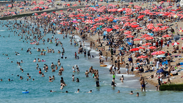 Một bãi biển ở Anh đông nghẹt người đi tránh nóng ngày 19-7 - Ảnh: REUTERS