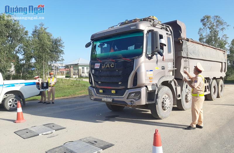 Cán bộ, chiến sĩ Phòng cảnh sát giao thông (Công an tỉnh) kiểm tra, xử lý xe chở quá tải ở Khu kinh tế Dung Quất.                                           Ảnh: B.S