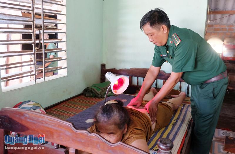 Thiếu tá Nguyễn Khắc Trung thăm khám, chữa trị bệnh về xương khớp cho một người dân. Ảnh: B.Hòa