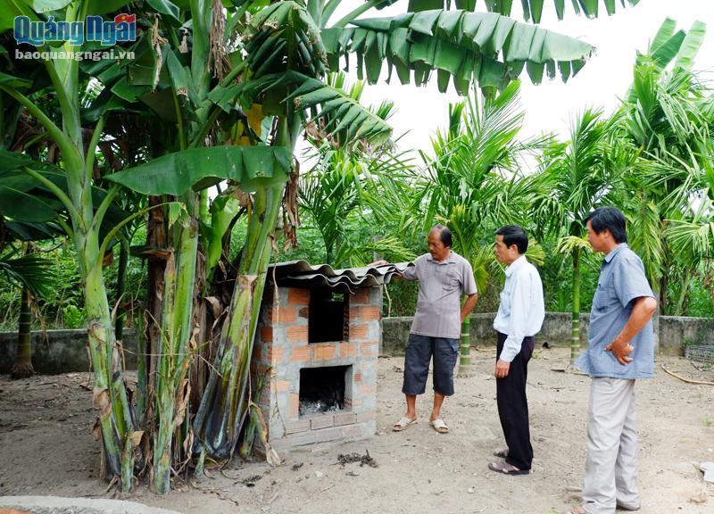 Ông Văn Anh Tuấn (bên trái), ở thôn Hà Nhai Bắc, xã Tịnh Hà (Sơn Tịnh) giới thiệu lò xử lý rác thải tại nhà của gia đình.             ẢNH: ĐĂNG SƯƠNG