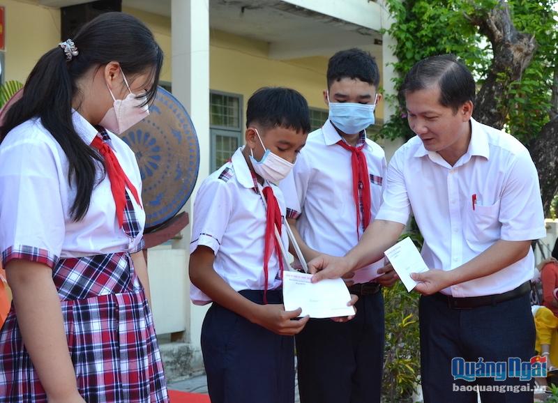 Tổng Biên tập Báo Quảng Ngãi Nguyễn Phú Đức trao học bổng cho học sinh.