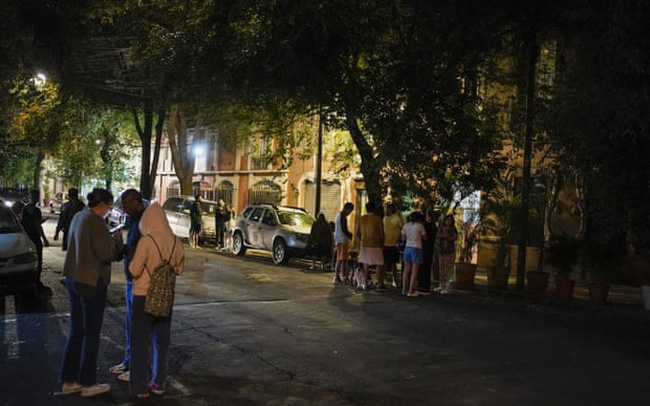 Người dân tập trung ở bên ngoài sau khi một trận động đất xảy ra ở bang Michoacán, Mexico. (Ảnh: AP)