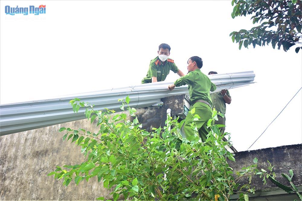 Công an huyện Sơn Tịnh và xã Tịnh Hiệp lợp lại mái nhà cho bà Nhung - xã Tịnh Hiệp. Ảnh Kim Cúc