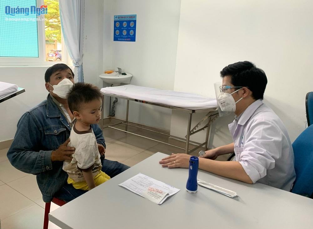 Cán bộ Trung tâm Y tế TP.Quảng Ngãi khám sang lọc cho trẻ trước khi cho uống vắc xin phòng bệnh bại liệt, tiêm vắc xin sởi – Rubella.