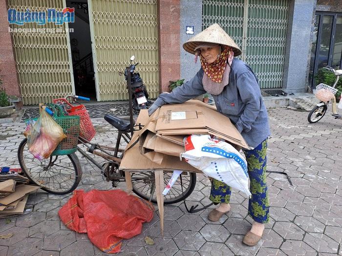 Chị Lê Thị Nở, ở thị trấn Trà Xuân (Trà Bồng), bên chiếc xe đạp cũ dùng để đi mua phế liệu của mình.