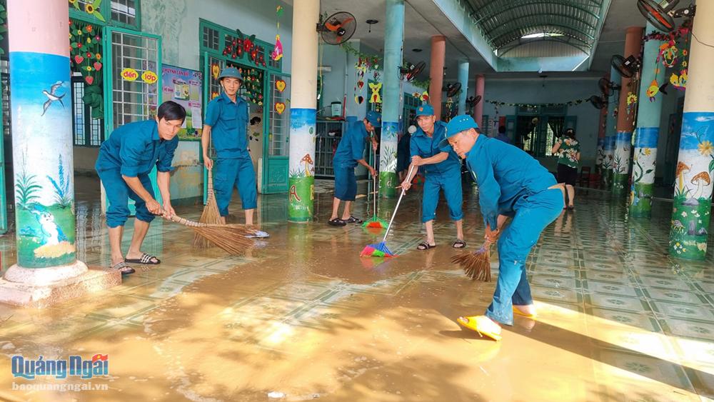 Lực lượng dân quân tự vệ cùng đoàn thanh niên xã tham gia vệ sinh tại Trường Mầm non Hành Dũng.