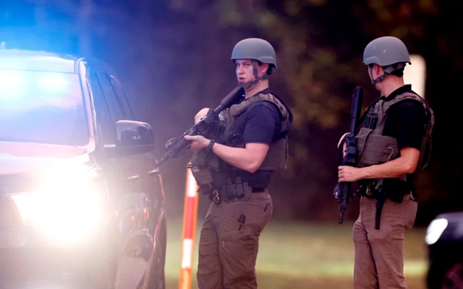 Lực lượng thực thi pháp luật đứng ở lối vào bãi đậu xe ở đường Neuse River Greenway tại Abington Lane sau vụ nổ súng ở Raleigh, ngày 13/10. (Ảnh: AP)