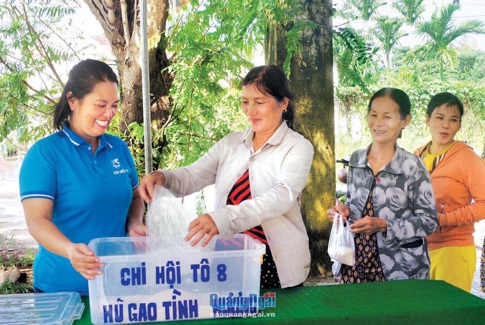 Chị Trần Thị Bé Ngân (bên trái) cùng phụ nữ tổ dân phố 8, phường Quảng Phú (TP.Quảng Ngãi) góp gạo vào mô hình “Hũ gạo tình thương”.                      Ảnh: H.THU