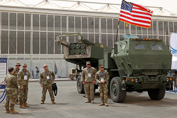Quân nhân Mỹ đứng bên hệ thống tên lửa cơ động cao M142 (HIMARS) - Ảnh: AFP