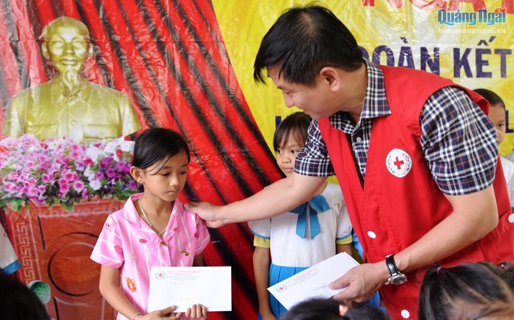 Đại diện Hội Chữ thập đỏ tỉnh trao quà cho các em học sinh.