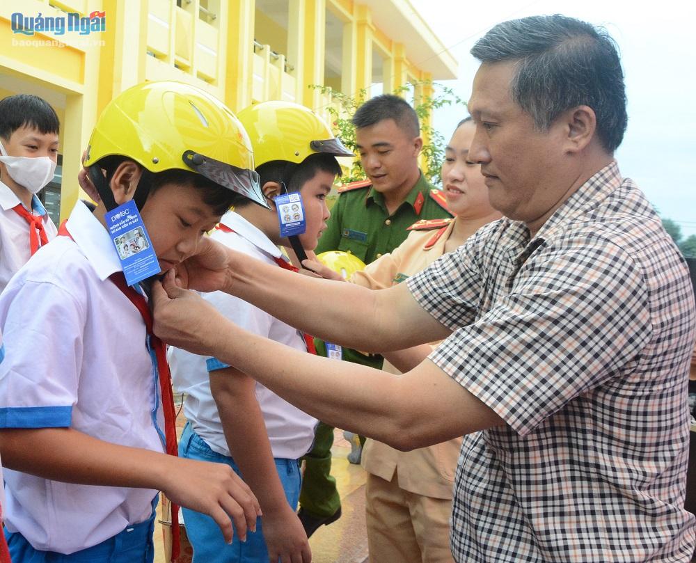 Trưởng ban ATGT tỉnh Phạm Văn Thanh trao mũ bảo hiểm cho học sinh.