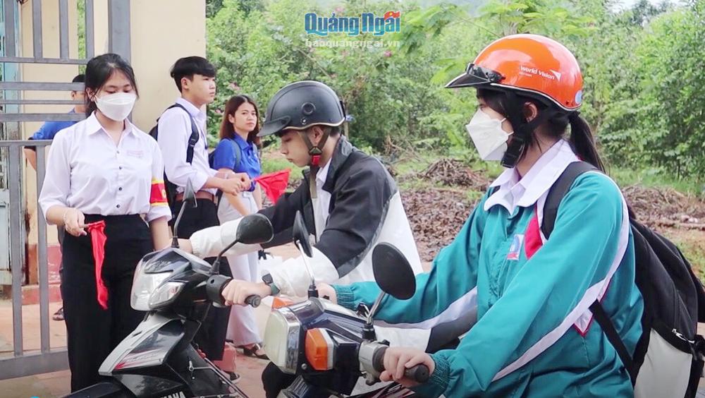 Nhóm Cờ đỏ của Trường THPT Minh Long tham gia điều tiết, hướng dẫn đảm bảo an toàn giao thông trước cổng trường. ẢNH: TRỊNH PHƯƠNG