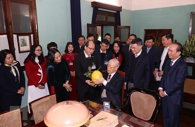  Cán bộ, nhân viên Khu di tích Chủ tịch Hồ Chí Minh kính tặng Tổng Bí thư Nguyễn Phú Trọng trái bưới trong vườn Bác- Ảnh: TTXVN