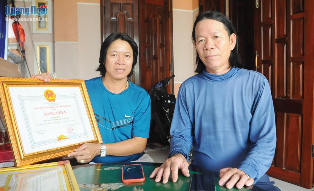 Anh Dương Tám Út (bên trái) và anh trai Dương Văn Xí cùng với Bằng khen của Chủ tịch UBND tỉnh. 