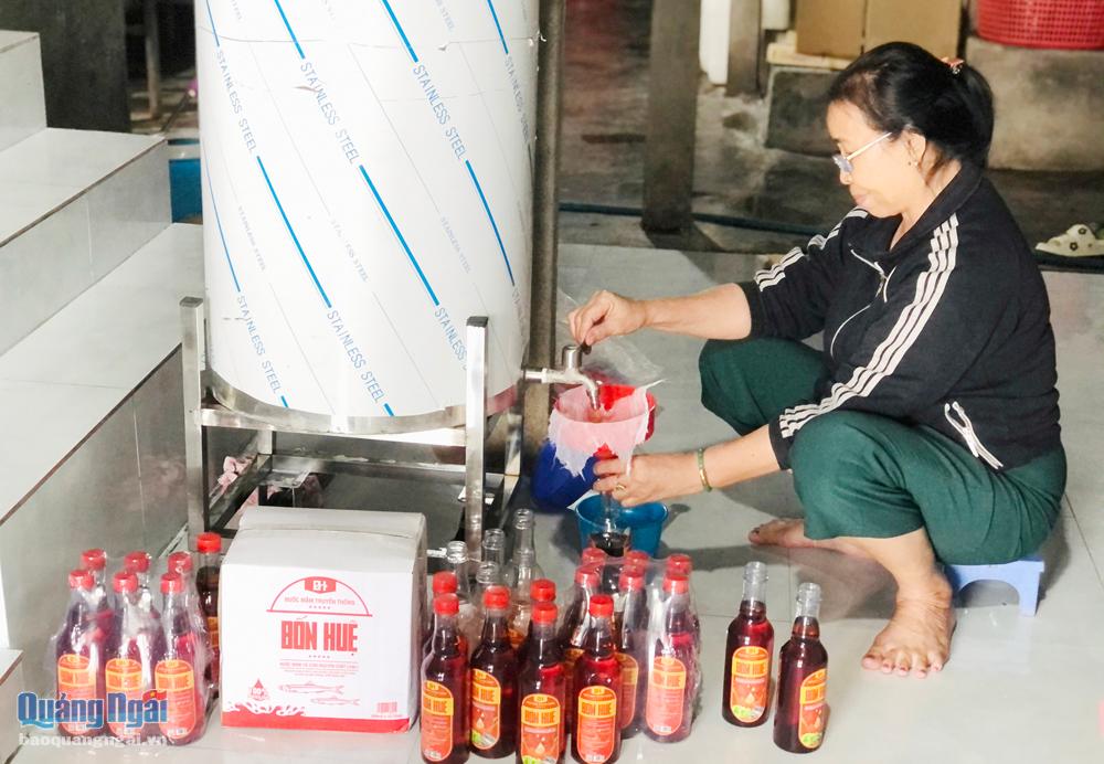 Bà Trần Thị Huê, ở tổ dân phố Thạnh Đức 1, phường Phổ Thạnh (TX.Đức Phổ) tỉ mỉ lọc nước mắm nhĩ.