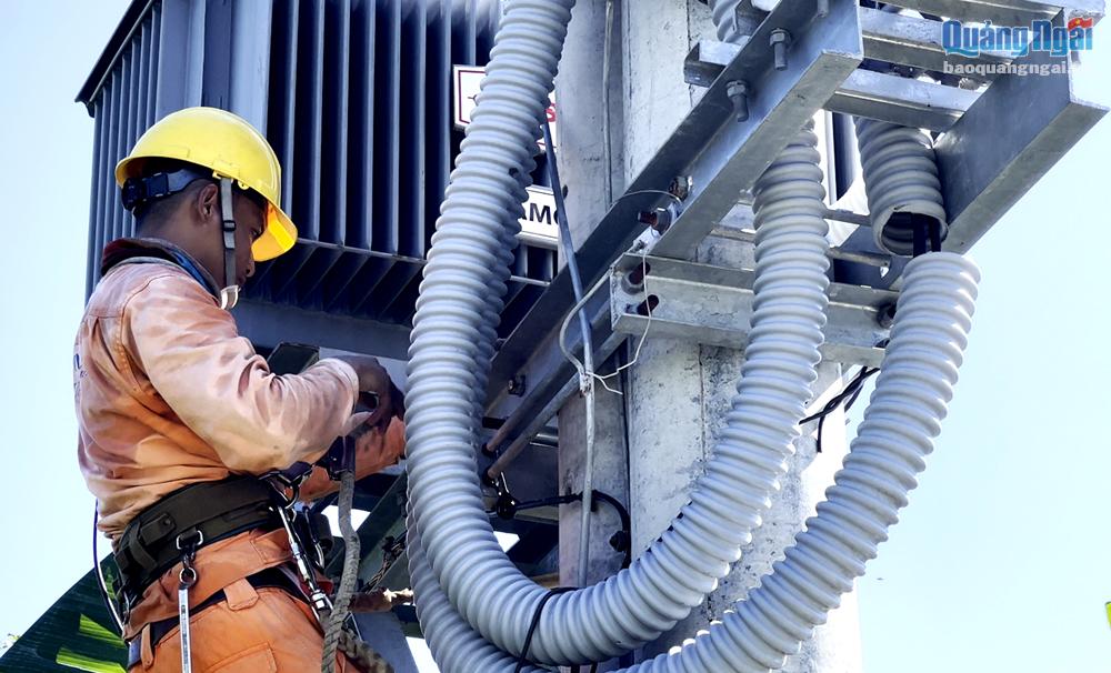 Công nhân Điện lực Sơn Tịnh thi công công trình nâng cao độ tin cậy cung cấp điện cho khách hàng.