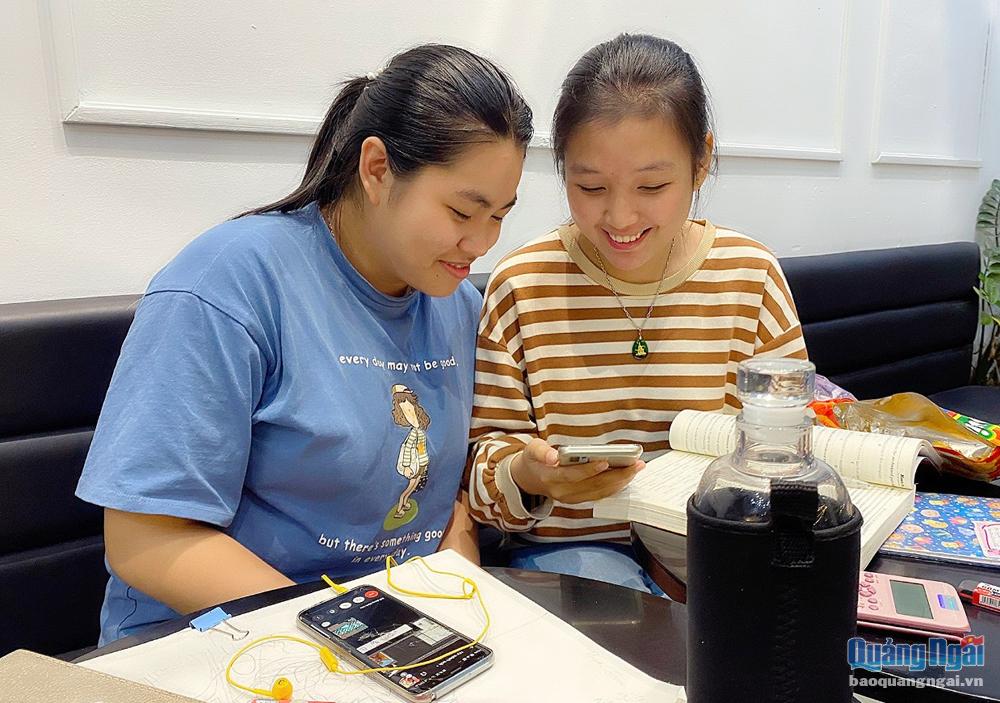 Em Nguyễn Trần Khánh Huyền (bên trái), lớp 12C10, Trường THPT Trần Quốc Tuấn, cùng bạn sử dụng mạng xã hội để giải trí sau thời gian học tập.