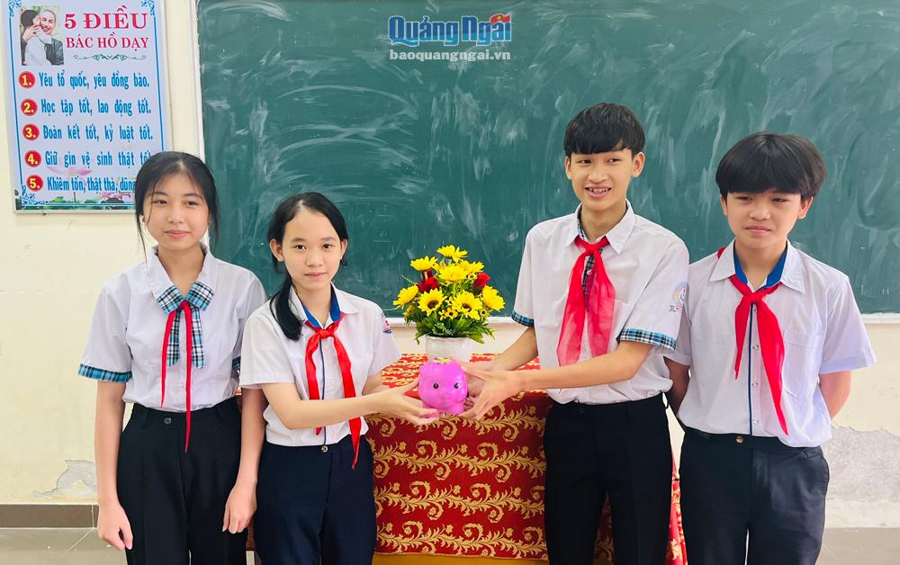 Học sinh Trường THCS Hành Tín Đông (Nghĩa Hành) đóng góp tiền vào heo đất để giúp các bạn học sinh khó khăn, ốm đau.