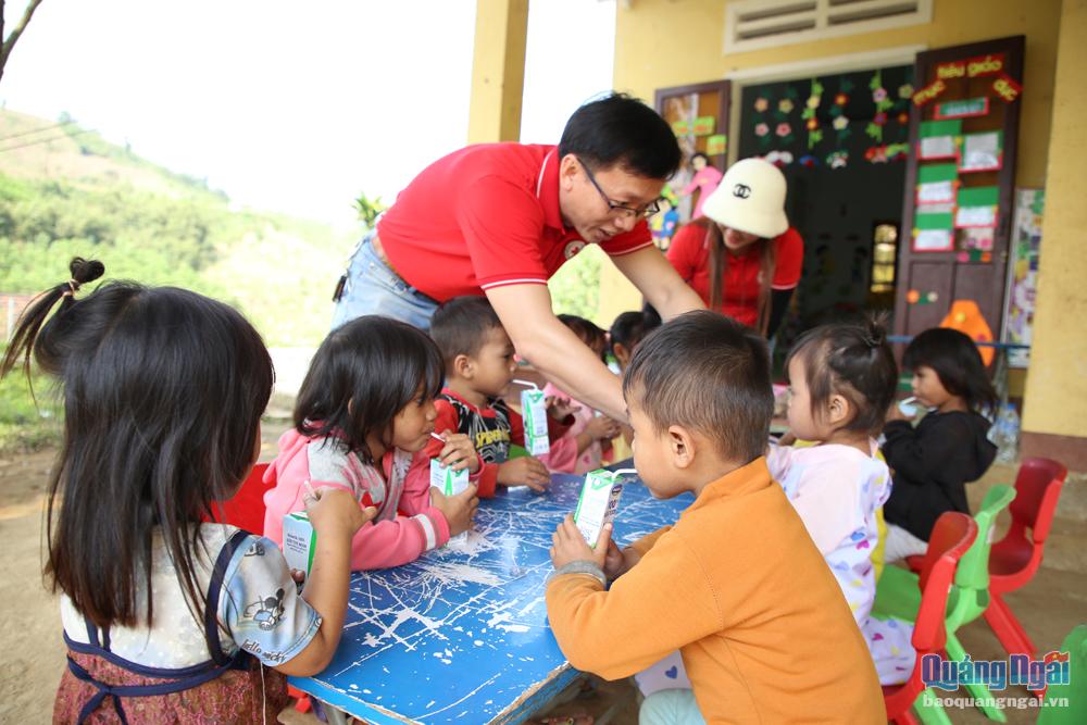 Đại diện Hội Chữ thập đỏ tỉnh trao sữa cho các em học sinh.