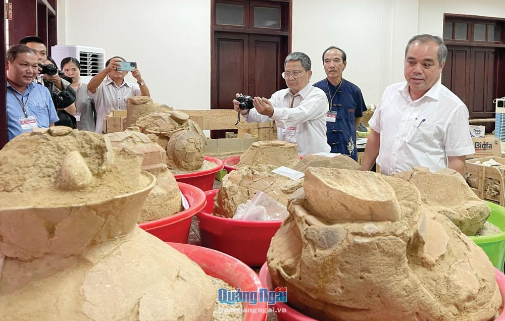 Phó Chủ tịch Thường trực UBND tỉnh Trần Hoàng Tuấn (bên phải) tham quan hiện vật mộ chum, thuộc Văn hóa Sa Huỳnh. Ảnh: Kim Ngân
