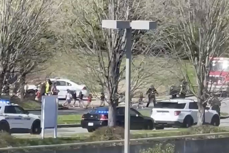 Các nhân viên an ninh hướng dẫn các học sinh rời khỏi hiện trường vụ nổ súng tại Trường Tiểu học Covenant ở Nashville, ngày 27/3/2023. (Ảnh chụp từ video, nguồn: Jozen Reodica/AP)
